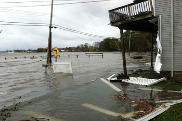 mage of a flooded roadway/parking lot and storm damaged structure